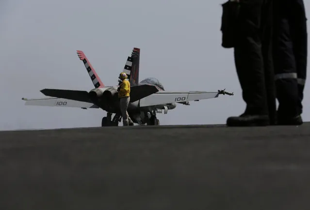 A U.S. military plane takes off from the flight deck of the USS Carl Vinson aircraft carrier in the Persian Gulf, Thursday, March 19, 2015. U.S. aircraft aboard the Carl Vinson as well as French military jets aboard the nearby French carrier Charles de Gaulle are flying missions over Iraq in the fight against Islamic State militants. (Photo by Hasan Jamali/AP Photo)