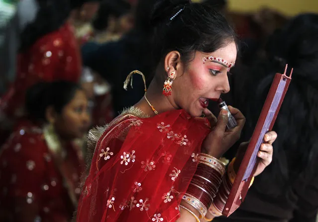A bride gets her make-up done before the start of a mass marriage ceremony at Noida on the outskirts of New Delhi December 17, 2011. (Photo by Parivartan Sharma/Reuters)