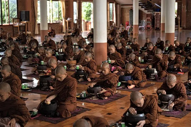 Buddhist novice monks have lunch at a monastery in Yangon on July 13, 2023. (Photo by Sai Aung Main/AFP Photo)