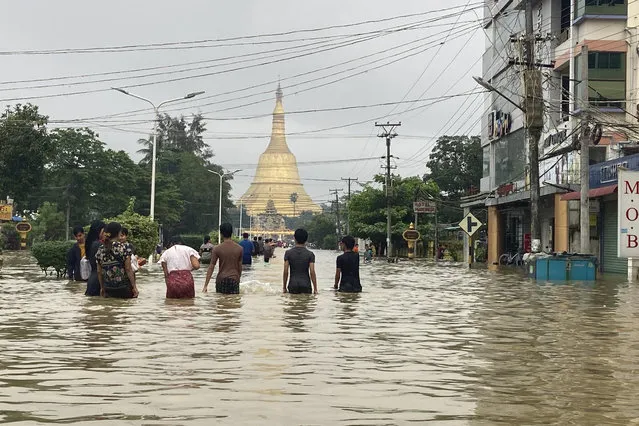 Local residents wade through a flooded road near Shwe Maw Taw pagoda in Bago, about 80 kilometers (50 miles) northeast of Yangon, Myanmar, Monday, October 9, 2023. (Photo by Thein Zaw/AP Photo)