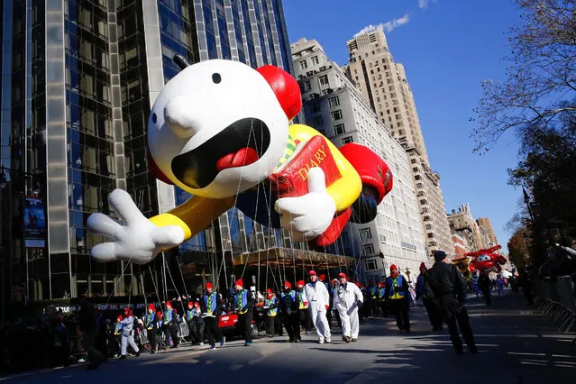 Greg Heffley from the “Diary of a Wimpy Kid” series balloon passes by windows of a building on Central Park West during the 92nd annual Macy's Thanksgiving Day Parade in New York, Thursday, November 22, 2018. (Photo by Eduardo Munoz Alvarez/AP Photo)