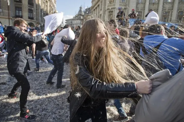 Feathers fly as youngsters engage in a pillow fight downtown Bucharest, Romania, Saturday, April 4, 2015. (Photo by Vadim Ghirda/AP Photo)