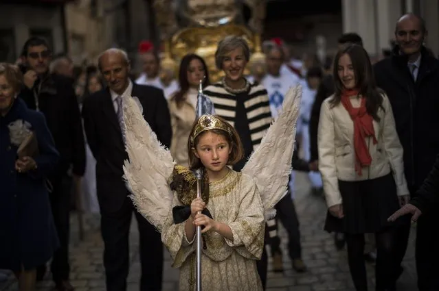 Eight-year-old Alba Oroz, wearing an angel costume takes part during the Easter Sunday ceremony “Descent of the Angel”, during Holy Week in the small town of Tudela, northern Spain, Sunday, April 5, 2015. (Photo by Alvaro Barrientos/AP Photo)