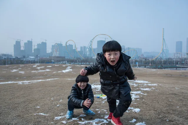 Twins play in front of a new-built residential area on February 1, 2016 in Hefei, China. (Photo by Xiao Lu Chu/Getty Images)