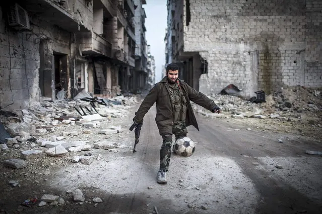 A Syrian rebel plays football in the Saif al-Dawlah neighborhood of Aleppo, Syria, Wednesday, January 2, 2013. (Photo by Andoni Lubacki/AP Photo)