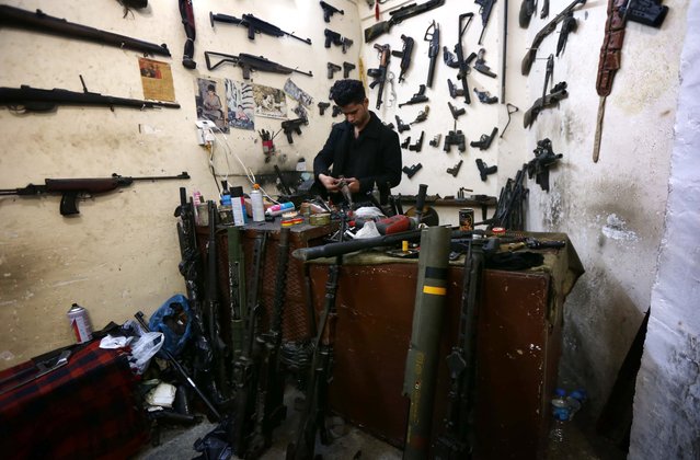 Hakim, an Iraqi Kurdish man, works at his workshop beneath the main market of Erbil, the capital of the autonomous Kurdish region of northern Iraq, where he repairs weapons for Kurdish Peshmerga fighters fighting against Islamic State (IS) group jihadistst for free on February 16, 2016. (Photo by Safin Hamed/AFP Photo)