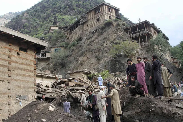 Locals search for victims of a mudslide following heavy flooding in Nuristan province, east of Kabul, Afghanistan, Saturday, July 31, 2021. (Photo by Ubidullah Abid/AP Photo)