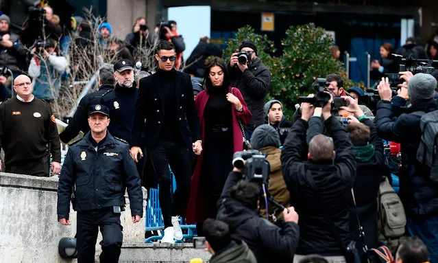 Juventus' forward and former Real Madrid player Cristiano Ronaldo leaves with his Spanish girlfriend Georgina Rodriguez after attending a court hearing for tax evasion in Madrid on January 22, 2019. Ronaldo is expected to be given a hefty fine after Spanish tax authorities and the player's advisors made a deal to settle claims he hid income generated from image rights when he played for Real Madrid. (Photo by Pierre-Philippe Marcou/AFP Photo)