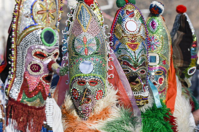 Dancers, known as “Kukeri”, perform on January 27, 2019 during the International Festival of the Masquerade Games in Pernik, near Sofia. The three-day festival, which started on January 25, has participants sporting multi-colored masks, covered with beads, ribbons and woolen tassels while the main dancer, ladened with bells to drive away sickness and evil spirits, sways like a wheat spikelet heavy with grain. (Photo by Nikolay Doychinov/AFP Photo)