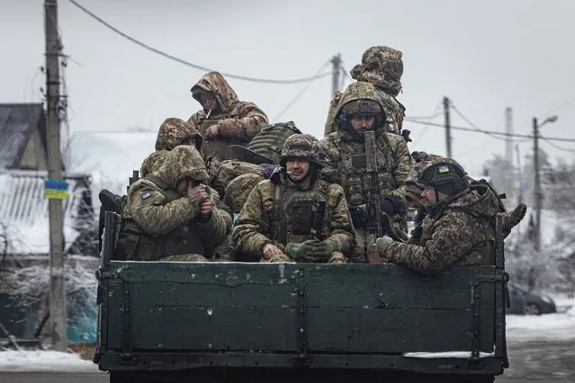 Ukrainian servicemen sit on the bed of a truck while driving in the Donetsk region, amid Russia’s attack on Ukraine on December 17, 2023. (Photo by Thomas Peter/Reuters)