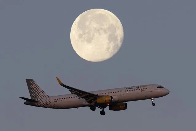 A Vueling Airbus A321 approaches for landing in Lisbon at sunrise, with the moon in the background, Tuesday, February 7, 2023. (Photo by Armando Franca/AP Photo)