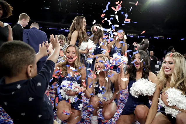 Isaiah Kennedy, left, of Rahway, N.J., throws confetti with Villanova cheerleaders after Villanova defeated Seton Hall 74-72 in an NCAA college basketball game in the championship of the Big East Conference tournament, Saturday, March 16, 2019, in New York. (Photo by Julio Cortez/AP Photo)