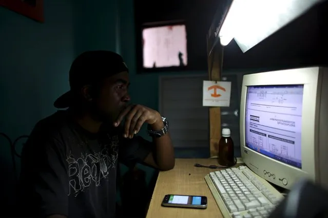 Informatics technician Yurkel Medina, 36, studies about new technologies at the mobile phone repair shop where he works in downtown Havana, February 23, 2016. (Photo by Alexandre Meneghini/Reuters)