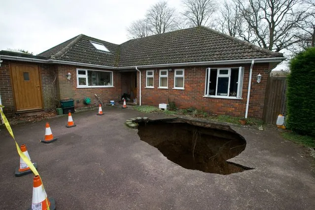 A view of the home of Phil and Liz Conran, in Main Road, Walter's Ash, High Wycombe, Buckinghamshire, after a 30ft-deep sinkhole opened up in the driveway yesterday and swallowed their car, on February 3, 2014. (Photo by Steve Parsons/PA Wire)