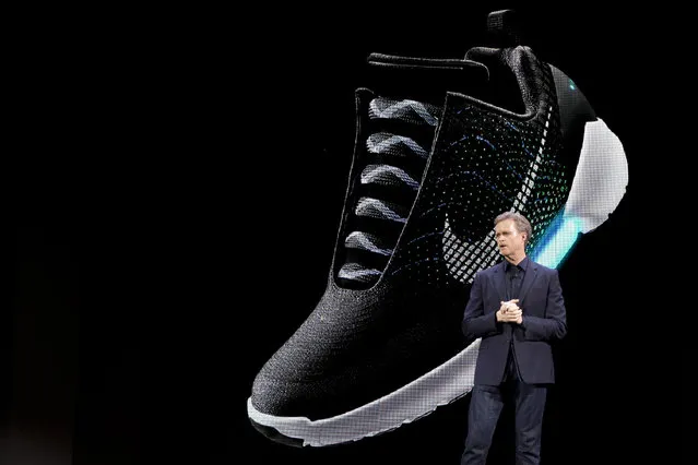 An image of the Nike HyperAdapt 1.0 is projected on a screen as Nike CEO Mark Parker speaks during a news conference, Wednesday, March 16, 2016, in New York. Nike Inc. has unveiled its first power-lacing sneaker – it allows users to make the fit looser or snugger on the fly by pressing buttons on the side of the shoe. Nike says that the potential for shoes with adaptive lacing is huge because it provides tailored-to-the-moment custom fit. When users step into the shoe, their heel will hit a sensor. (Photo by Mary Altaffer/AP Photo)