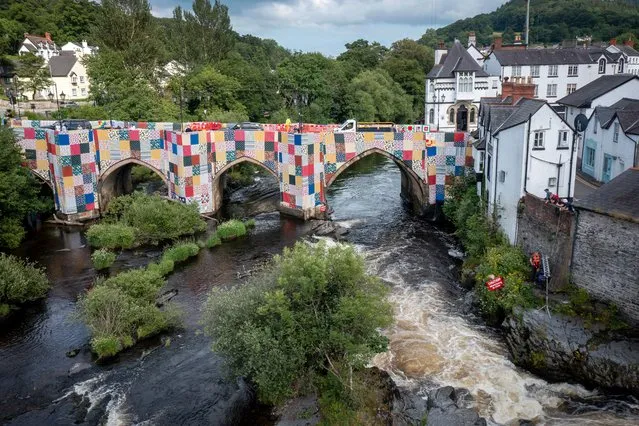 Patchwork panels entitled “Bridges, Not Walls” by artist Luke Jerram cover Llangollen Bridge on July 08, 2021 in Llangollen, Denbighshire. The Llangollen International Musical Eisteddfod, an annual festival starting this month, commissioned artist Luke Jerram to create the patchwork, inviting local residents and festival fans to submit 1m x 1m fabric squares reflecting the crafts and culture of Wales. (Photo by Christopher Furlong/Getty Images)