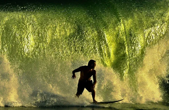 A surfer catches a wave in Rio de Janeiro on April 11, 2019. (Photo by Carl de Souza/AFP Photo) 