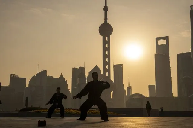 People practice tai chi in front of buildings in Pudong's Lujiazui Financial District in Shanghai, China, on Monday, February 19, 2024. Chinese stocks saw modest gains as onshore traders returned from the Lunar New Year holidays, with broader caution toward the market offsetting buoyant travel and spending data. (Photo by  Raul Ariano/Bloomberg)