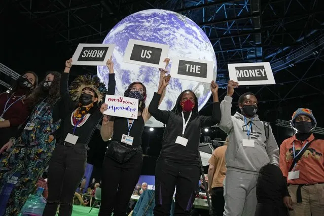 Climate activist Vanessa Nakate, third right, and other activists engage in a “Show US The Money” protest at the COP26 U.N. Climate Summit in Glasgow, Scotland, Monday, November 8, 2021. The U.N. climate summit in Glasgow gathers leaders from around the world, in Scotland's biggest city, to lay out their vision for addressing the common challenge of global warming. (Photo by Alastair Grant/AP Photo)