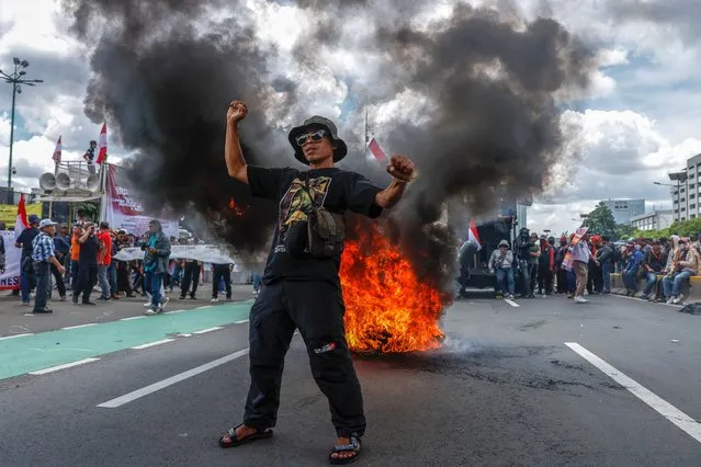 A protester shouts slogans near a burning tires barricade during a rally against alleged electoral fraud, outside of the parliament building in Jakarta, Indonesia, 05 March 2024. Hundreds of protesters staged a rally demanding the impeachment of Indonesian President Joko Widodo on accusation of his involvement on the election process which they claimed were fraudulent. (Photo by Mast Irham/EPA/EFE)