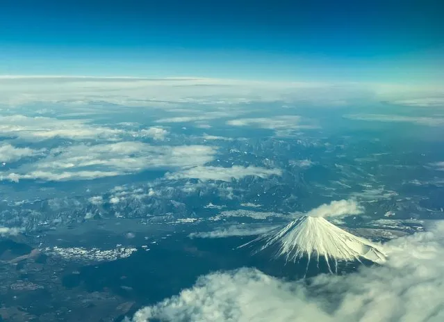 This aerial view of Mount Fuji, Japan's highest peak at 3,776 meters (12,388 feet), is seen from the window of a flight from Tokyo to Hong Kong, above Shizuoka Prefecture on March 1, 2024. (Photo by Philip Fong/AFP Photo)