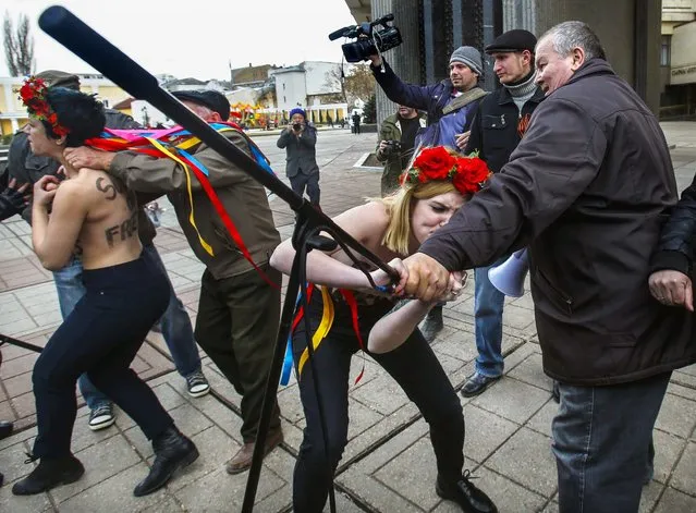 Femen women's rights activists protest against the war in front of parliament building in Simferopol, Ukraine. Lawmakers in Crimea called a March 16 referendum on whether to break away from Ukraine and join Russia instead, voting unanimously Thursday to declare their preference for doing so. (Photo by Sergei Grits/Associated Press)