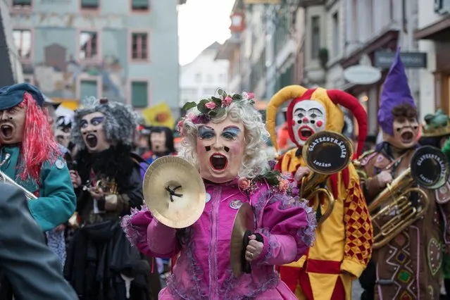 Masked Guggen music bands (brass and percussion carnival bands) parade through the streets at the beginning of the Lucerne Carnival in Lucerne, Switzerland, 23 February 2017. (Photo by Urs Flueeler/EPA)