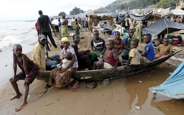 Burundian refugees sit on a wooden boat on the shores of Lake Tanganyika in Kagunga village in Kigoma region in western Tanzania, as they wait for MV Liemba to transport them to Kigoma township, May 18, 2015. (Photo by Thomas Mukoya/Reuters)