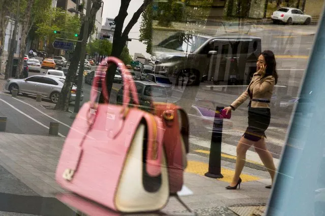 A woman is reflected in a show window displaying a handbag in the fashion district of Apgujeong in Seoul, May 7, 2015. (Photo by Thomas Peter/Reuters)