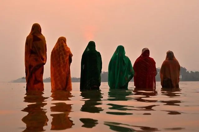 Hindu devotees offer prayers to the Sun god on the banks of river Brahmaputra during 'Chaiti Chhath Puja' festival in Guwahati on April 14, 2024. (Photo by Biju Boro/AFP Photo)
