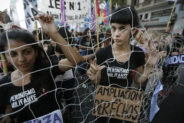 Women march covered with a fishing net, with a sign that reads in Spanish “More rights” during the International Women's Day march in Buenos Aires, Argentina, on Wednesday, March 8, 2017. Tens of thousands of people marched in Argentina's capital to demand equal rights and condemn violence against women. (Photo by Victor R. Caivano/AP Photo)