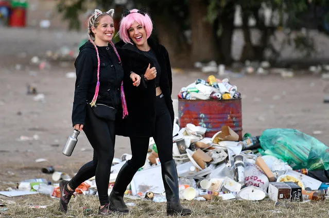 Festival-goers walk amongst the previous nights rubbish at Glastonbury Festival in Pilton, Britain, early 01 July 2019. The Glastonbury Festival of Contemporary Performing Arts is a five-day festival of contemporary performing arts that takes place in Pilton, Somerset, from 26 to 30 June. (Photo by Neil Hall/EPA/EFE)
