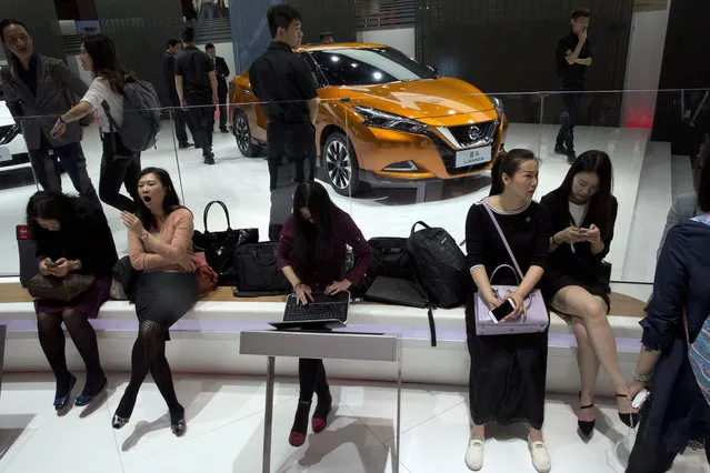 Visitors to the Auto China 2016 rest at the Nissan booth in Beijing, China, Monday, April 25, 2016. (Photo by Ng Han Guan/AP Photo)