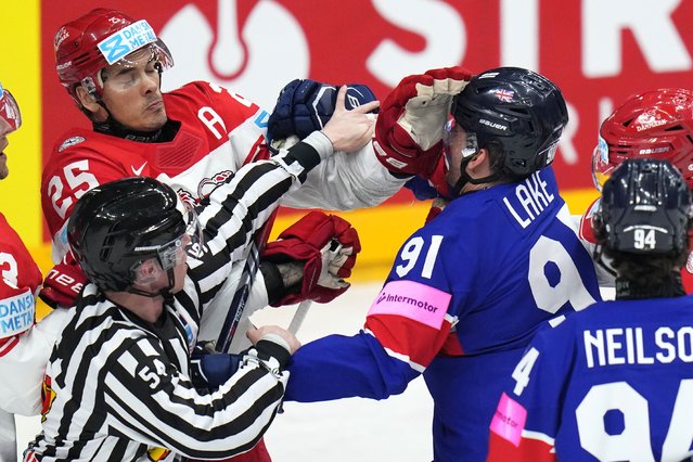 A referee tries to break up a fight between Denmark's Oliver Lauridsen, left, and Britain's Ben Lake during the preliminary round match between Great Britain and Denmark at the Ice Hockey World Championships in Prague, Czech Republic, Friday, May 17, 2024. (Photo by Petr David Josek/AP Photo)