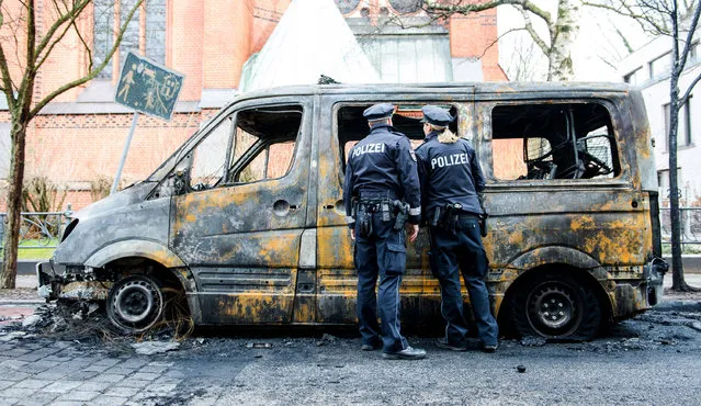 Two policemen stand near the burnt-out police bus in Hamburg, Germany on March 17, 2017. Extreme-left activists have claimed responsibility for an arson attack on two police vehicles overnight in Hamburg. Police said they suspected the attack could be related to the July G20 summit. The port city has been cited as a hub for extreme-left activism. (Photo by Daniel Bockwoldt/DPA)