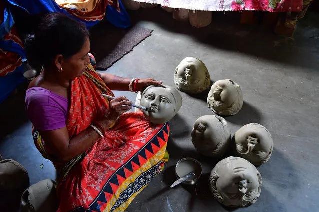 Manju Saha, an idol maker, prepares faces of Durga before an annual festival celebrating the Hindu goddess in Agartala, India on July 21, 2019. (Photo by Abhisek Saha/Barcroft Media)