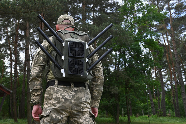 A Ukrainian serviceman tests an anti-drone backpack during a presentation of radio-electronic warfare (WB) and radio-electronic intelligence (PER) systems of the Ukrainian company Kvertus in Lviv region on May 28, 2024, amid the Russian invasion of Ukraine. The event was organized by the charity foundation 'Zavzhdy UA' (Forever Ukraine) with the Ukrainian company Kvertus. (Photo by Yuriy Dyachyshyn/AFP Photo)