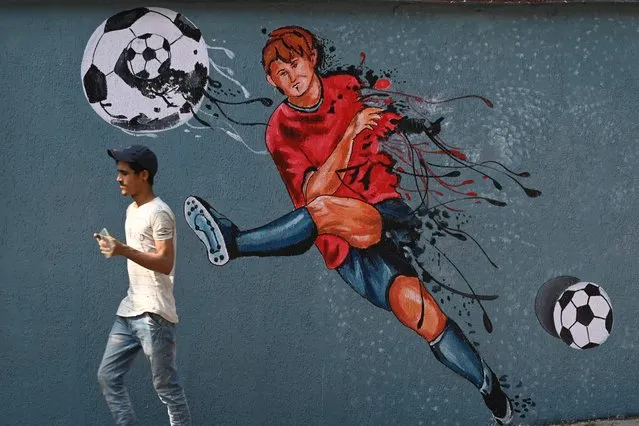 A pedestrian walks past a women’s football wall mural ahead of the Asian Football Confederation (AFC) Women's Asian Cup India 2022 Finals at Vashi in Navi Mumbai on January 16, 2022. (Photo by Indranil Mukherjee/AFP Photo)