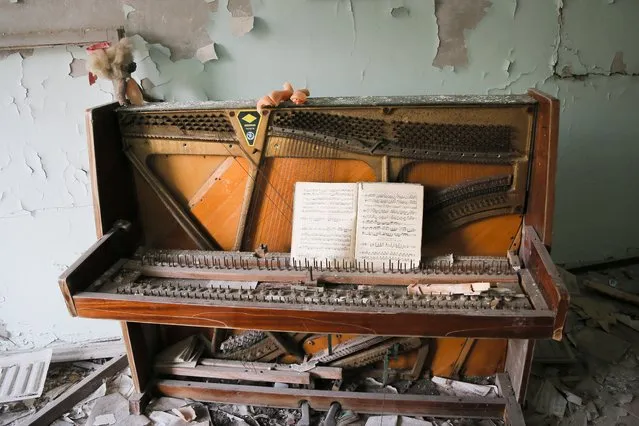 In this photo taken Wednesday, April 5, 2017, a decrepit piano stands in a school in the deserted town of Pripyat, some 3 kilometers (1.86 miles) from the Chernobyl nuclear power plant Ukraine. (Photo by Efrem Lukatsky/AP Photo)