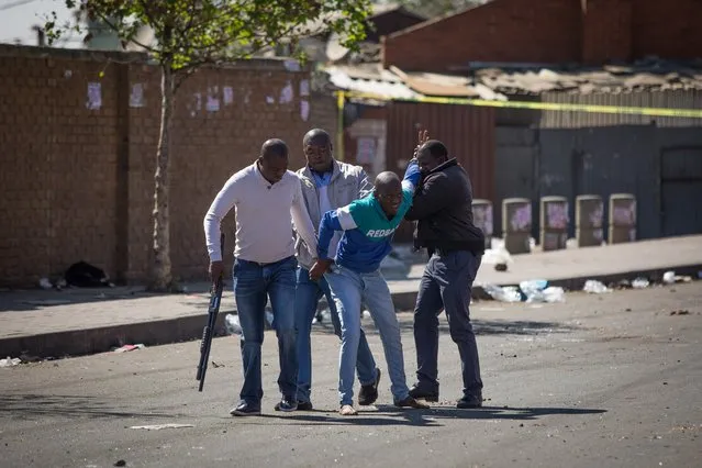 South African police officers detain a looter in the Johannesburg township of Alexandra on September 3, 2019 after South Africa's financial capital was hit by a new wave of anti-foreigner violence. The township was scene to a second night of urban rioting in Johannesburg, where hundreds of people marched through the streets on September 2 in an unusually large expression of anti-foreigner sentiment. Such violence breaks out sporadically in South Africa where many nationals blame immigrants for high unemployment, particularly in manual labour. (Photo by Guillem Sartorio/AFP Photo)