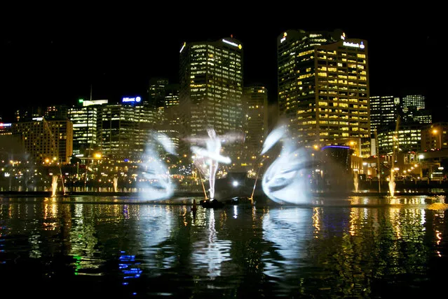 A light show featuring a ballet dancer and swans from Swan Lake is projected onto spraying water by the Vivid Aquatique Water Theatre during a preview of the Vivid Sydney light and music festival May 21, 2014. For 18 days beginning on May 23 the Vivid Sydney festival,  one of the world's largest creative industry forums, will combine outdoor lighting sculptures and installations. (Photo by Jason Reed/Reuters)