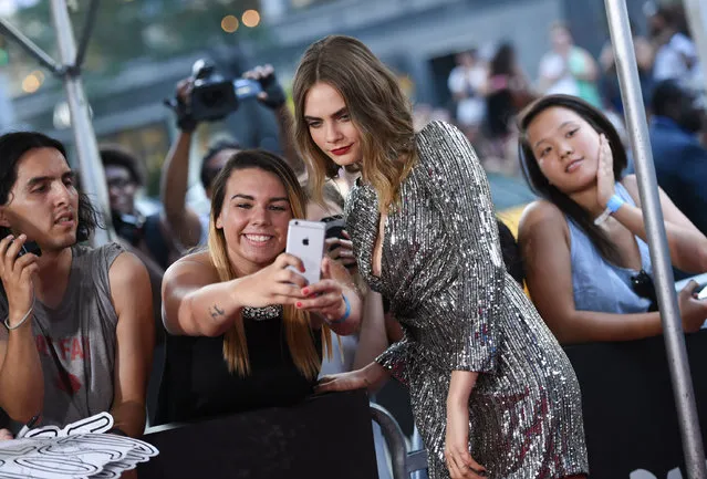 Actress Cara Delevingne poses with a fan at the premiere of “Paper Towns” at AMC Loews Lincoln Square on Tuesday, July 21, 2015, in New York. (Photo by Evan Agostini/Invision/AP Photo)