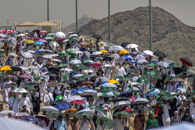 Muslim pilgrims use umbrellas to shield themselves from the sun as they arrive to cast stones at pillars in the symbolic stoning of the devil, the last rite of the annual hajj, in Mina, near the holy city of Mecca, Saudi Arabia, Tuesday, June 18, 2024. Muslim pilgrims were wrapping up the Hajj pilgrimage in the deadly summer heat on Tuesday with the third day of the symbolic stoning of the devil, and the farewell circling around Kaaba in Mecca's Grand Mosque. (Photo by Rafiq Maqbool/AP Photo)