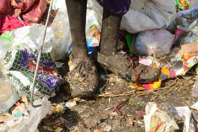 An Indian woman's feet are pictured as she collects recyclable items at a garbage dump on the outskirts of Hyderabad on June 5, 2017, on World Environment Day. The UN declared the 2017 theme for World Environment Day is “Connecting People to Nature”. (Photo by Noah Seelam/AFP Photo)