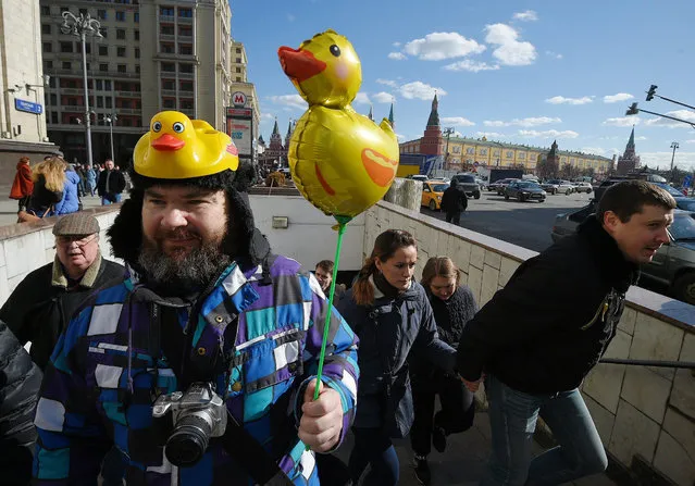 A protester holds a yellow duck toy, a new symbol of corruption during anti-corruption demonstrations on March 26, 2017 in Moscow, Russia. Thousands of people crowded for an unsanctioned protest against  Prime Minister Dmitry Medvedev after reports by Russia's  opposition leader Alexei Navalny's group claiming that Medvedev has amassed a collection of mansions, yachts and vineyards, and also a house for raising ducks. (Photo by Alexander Miridonov/Kommersant via Getty Images)