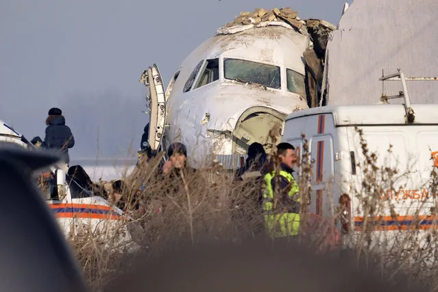 Police stand guard as rescuers assist on the site of a plane crashed near Almaty International Airport, outside Almaty, Kazakhstan, Friday, December 27, 2019. The Kazakhstan plane with 98 people aboard crashed shortly after takeoff early Friday. (Photo by Vladimir Tretyakov/AP Photo)