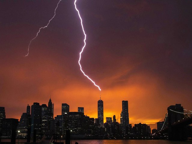 Lightning strikes One World Trade Center in Manhattan as the sun sets behind the city after a summer storm in New York on July 2, 2014. (Photo by Lucas Jackson/Reuters)