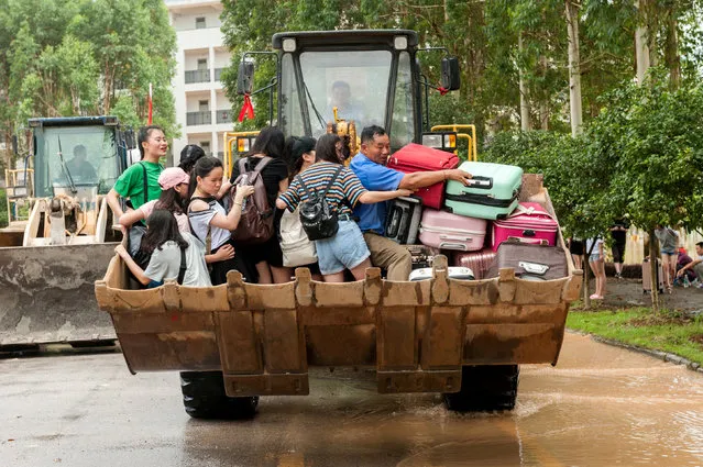 Students are transferred by a forklift through a flooded area at a college in Guilin, Guangxi province, China on July 3, 2017. (Photo by Reuters/Stringer)