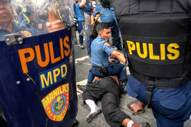 A police officer pins an activist to the ground after blocking him from marching during a protest commemorating the 52nd  anniversary of the 1972 Martial Law declaration in Manila, Philippines, on September 21, 2024. (Photo by Lisa Marie David/Reuters)