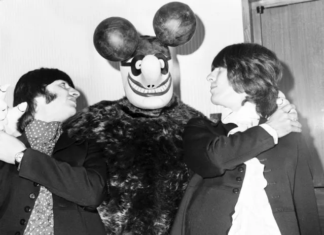 Ringo Starr, left, and George Harrison of The Beatles pose with “Blue Meanie”, one of the characters in the animated film “Yellow Submarine”, at the film's launch in Knightsbridge, London, July 8, 1968. (Photo by Laurence Harris/AP Photo)